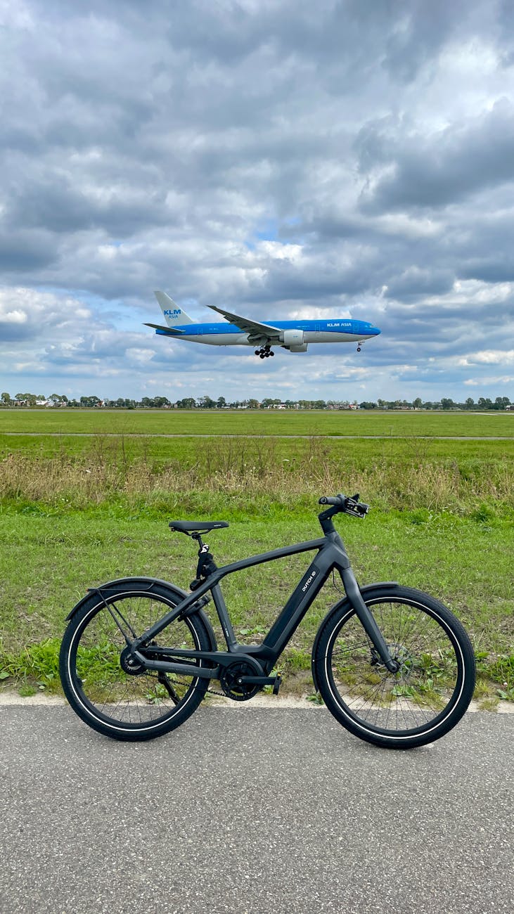 black bicycle with airplane in the background